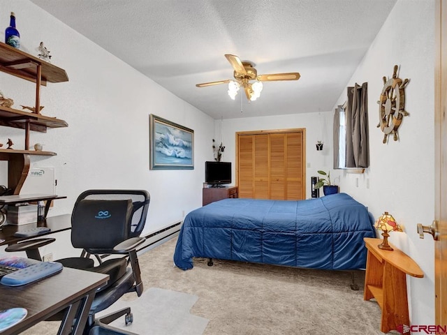 bedroom featuring carpet flooring, an office area, a textured ceiling, a ceiling fan, and a closet