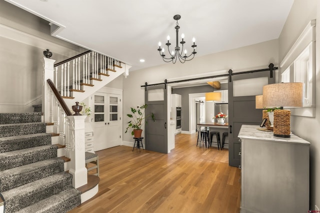 414 N Spruce St, Gunnison, CO 81230 - entryway with a barn door, stairway, light wood finished floors, baseboards, and a chandelier