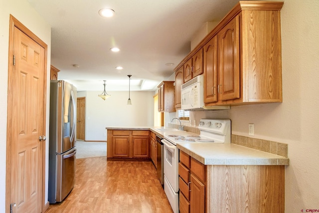 801 L Way, Cortez, CO 81321 - kitchen with stainless steel appliances, a sink, a peninsula, light wood-style floors, and light countertops