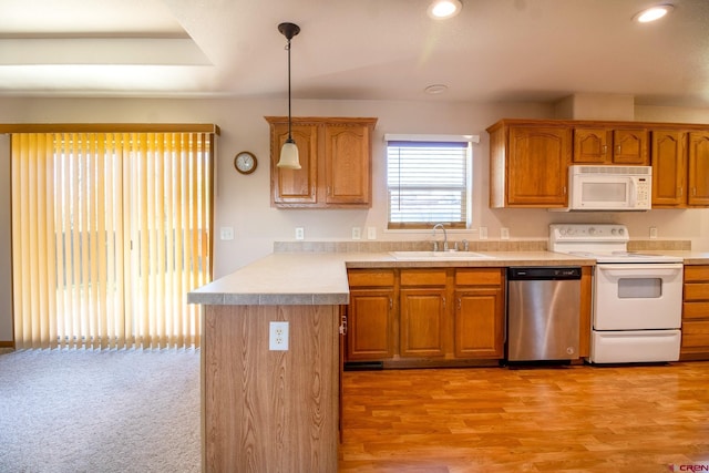 801 L Way, Cortez, CO 81321 - kitchen featuring white appliances, a sink, a peninsula, light countertops, and hanging light fixtures