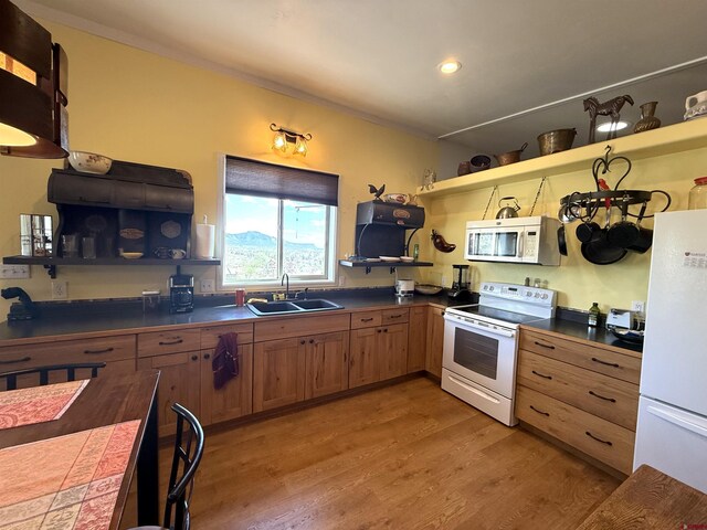 8041/2 S Broadway, Cortez, CO 81321 - kitchen featuring white appliances, open shelves, a sink, dark countertops, and light wood finished floors