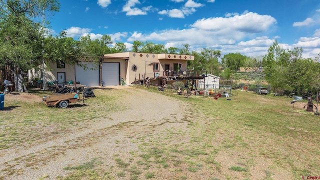 8041/2 S Broadway, Cortez, CO 81321 - southwest-style home with an attached garage, dirt driveway, stucco siding, and a front lawn