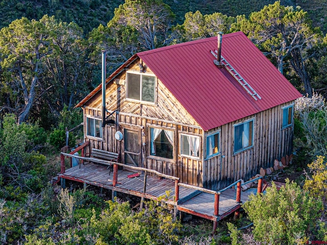 351 Slide Down Rd, Crawford, CO 81415 - rear view of house featuring a wooden deck, metal roof, a forest view, and board and batten siding
