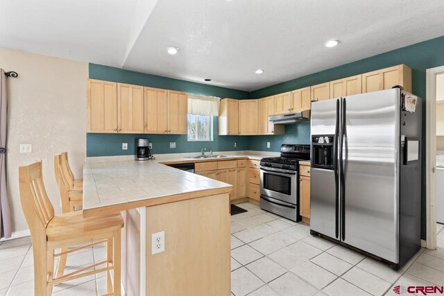 19496 E Rd, Delta, CO 81416 - kitchen featuring stainless steel appliances, light brown cabinets, a peninsula, a sink, and recessed lighting