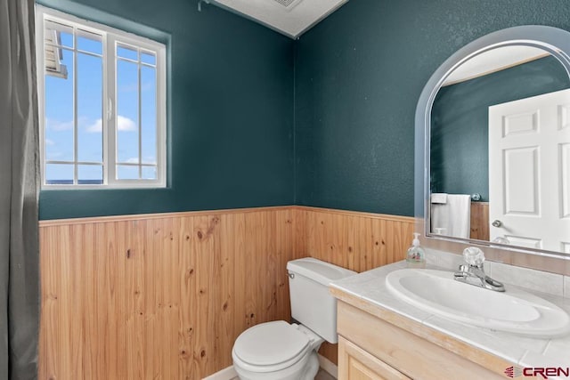 19496 E Rd, Delta, CO 81416 - half bath featuring wainscoting, toilet, wooden walls, and vanity