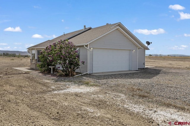19496 E Rd, Delta, CO 81416 - view of property exterior featuring an attached garage and a shingled roof