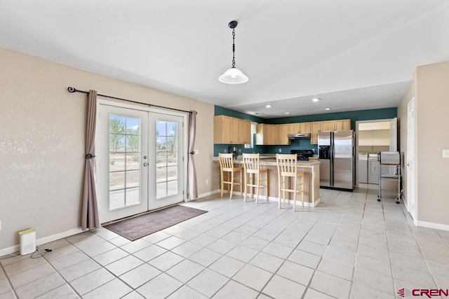 19496 E Rd, Delta, CO 81416 - kitchen featuring stainless steel fridge with ice dispenser, washer and clothes dryer, light brown cabinets, under cabinet range hood, and lofted ceiling