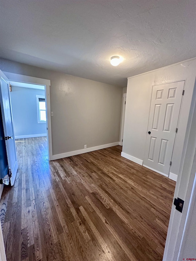 2375 W 2nd Ave, Durango, CO 81301 - empty room featuring dark wood-style flooring, baseboards, and a textured ceiling