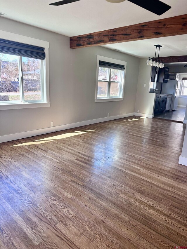 2375 W 2nd Ave, Durango, CO 81301 - unfurnished living room featuring dark wood finished floors, baseboards, and beamed ceiling