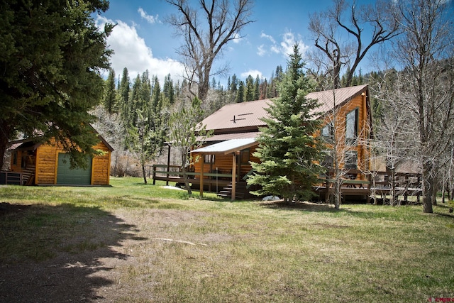 view of grassy yard featuring a deck and an outdoor structure