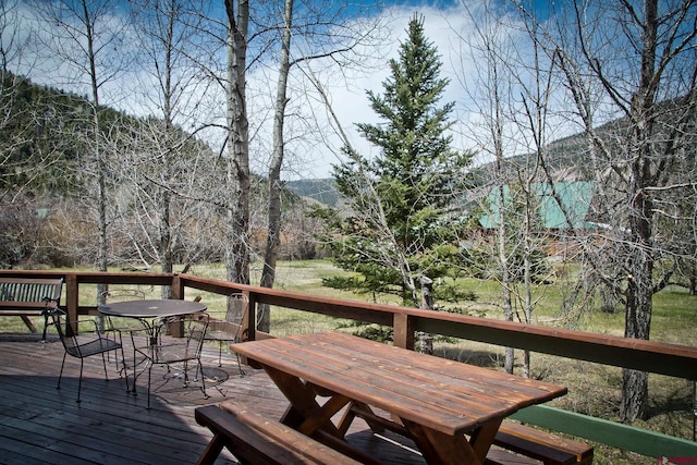 wooden deck featuring outdoor dining area and a mountain view