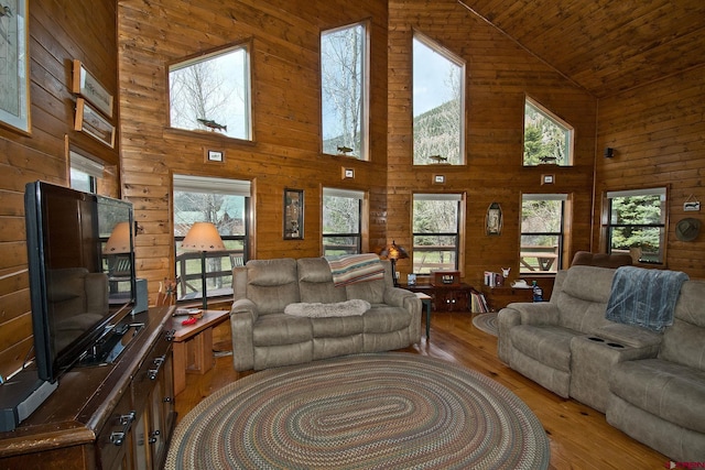 living room featuring high vaulted ceiling, light wood-style flooring, wood walls, and wood ceiling