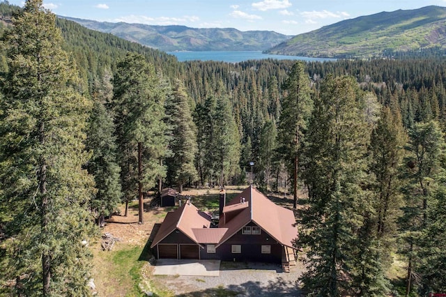 view of subject property featuring a forest and a water and mountain view