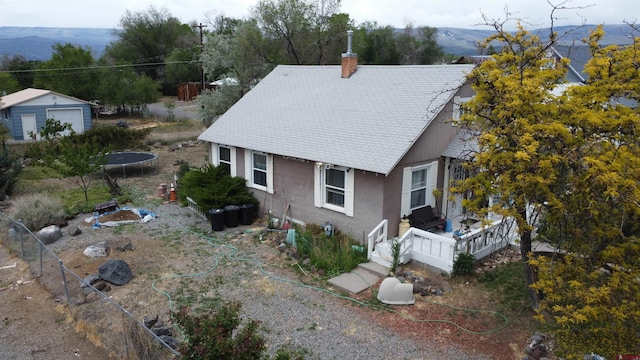 230 NW 5th St, Cedaredge, CO 81413 - rear view of house featuring a chimney, stucco siding, and a trampoline