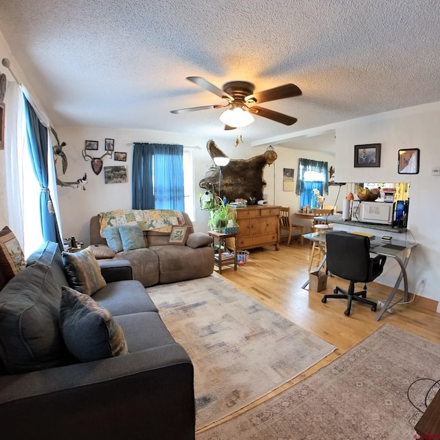 230 NW 5th St, Cedaredge, CO 81413 - living room featuring a textured ceiling, ceiling fan, a desk, and light wood-style flooring