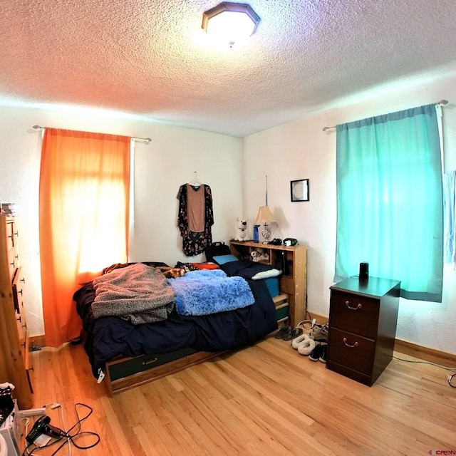 230 NW 5th St, Cedaredge, CO 81413 - bedroom featuring light wood-type flooring, a textured ceiling, and baseboards