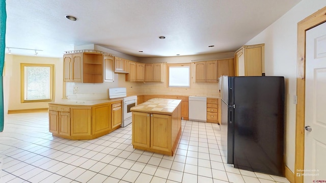 46 Camino Baca Grande, Crestone, CO 81131 - kitchen with white appliances, a kitchen island, open shelves, tile counters, and light brown cabinetry
