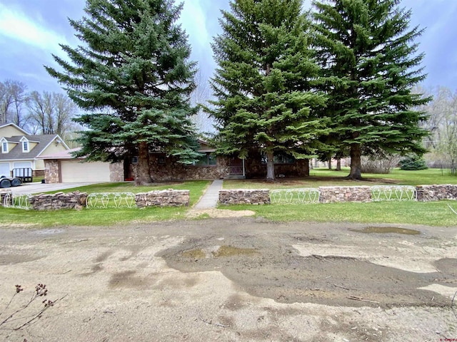 622 Rio Vista Rd, Gunnison, CO 81230 - obstructed view of property featuring stone siding, a garage, and a front lawn