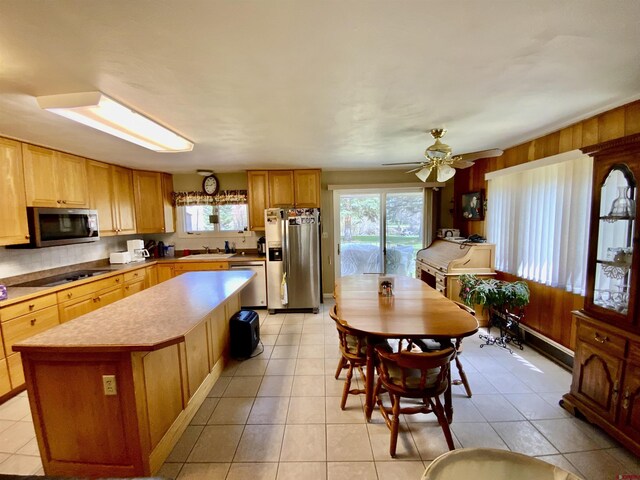 622 Rio Vista Rd, Gunnison, CO 81230 - kitchen featuring stainless steel appliances, a sink, a kitchen island, light countertops, and light tile patterned floors
