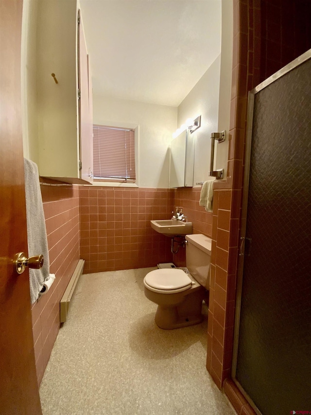 622 Rio Vista Rd, Gunnison, CO 81230 - bathroom with tile walls, toilet, a shower stall, a sink, and a wainscoted wall