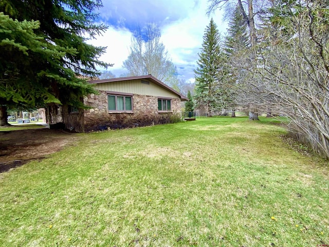 622 Rio Vista Rd, Gunnison, CO 81230 - view of side of property featuring stone siding and a lawn