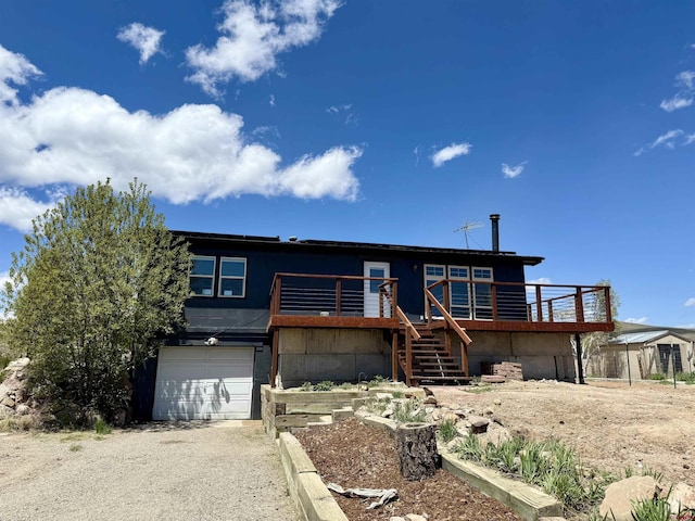 15 Tomichi Ln, Gunnison, CO 81230 - view of front of house with an attached garage, stairway, gravel driveway, and a deck