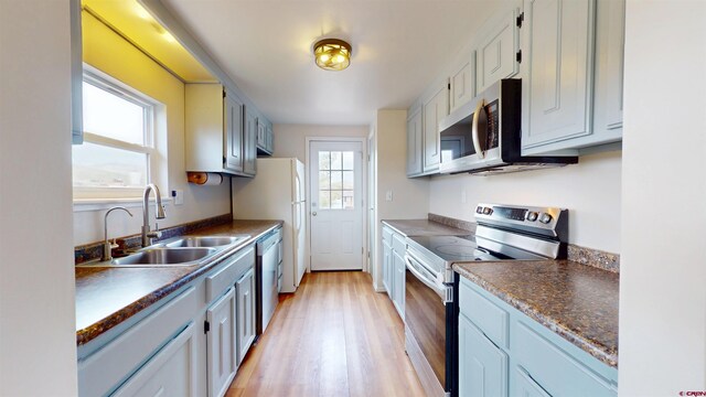 15 Tomichi Ln, Gunnison, CO 81230 - kitchen featuring appliances with stainless steel finishes, a sink, light wood-type flooring, and dark countertops