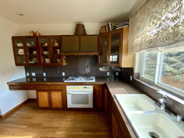 865 County Road 17, Gunnison, CO 81230 - kitchen with white appliances, a sink, glass insert cabinets, light wood finished floors, and backsplash