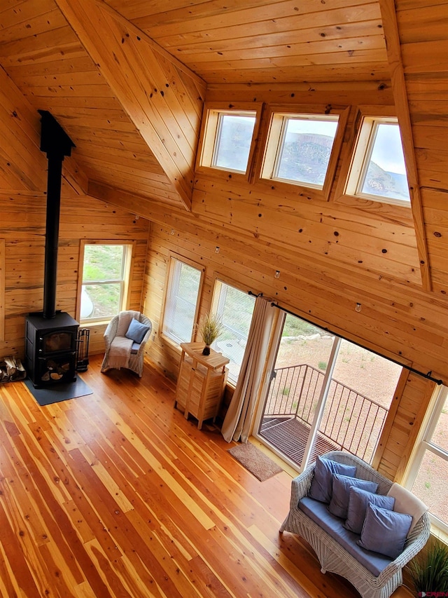 11975 US Highway 50, Gunnison, CO 81230 - living room with a wood stove, light wood-type flooring, wooden ceiling, wooden walls, and lofted ceiling