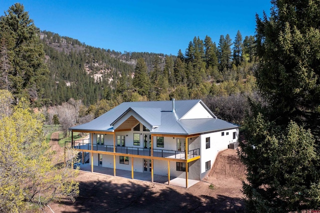 26217 Rd 38.5, Dolores, CO 81323 - back of house featuring a forest view, a patio, metal roof, stucco siding, and a deck