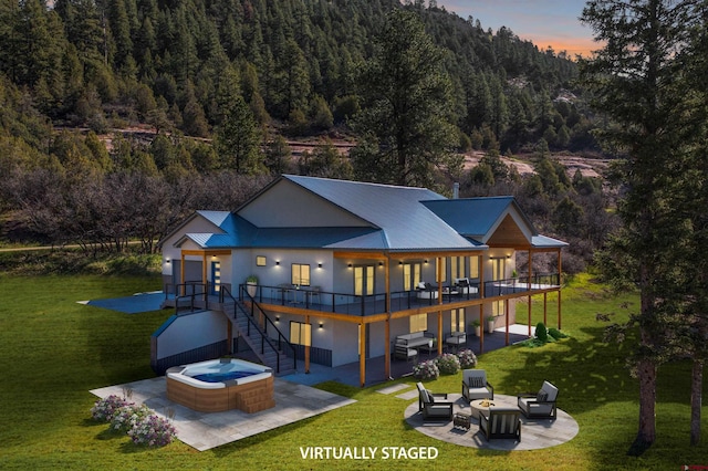 26217 Rd 38.5, Dolores, CO 81323 - rear view of house featuring a hot tub, a patio, stucco siding, a view of trees, and a lawn