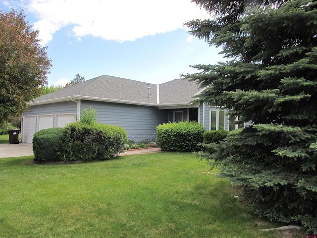 1770 Stellar Pl, Montrose, CO 81401 - view of side of property with a garage, a yard, and roof with shingles