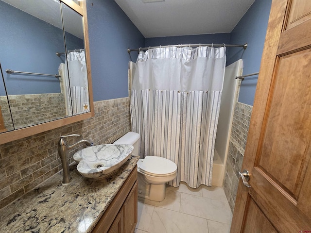 4189 Crowther Ln, Alamosa, CO 81101 - full bath with vanity, toilet, shower / tub combo with curtain, tile walls, and wainscoting