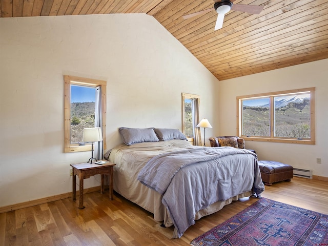 741 Big Wall Ln, La Veta, CO 81055 - bedroom featuring a baseboard radiator, multiple windows, wooden ceiling, wood finished floors, and high vaulted ceiling