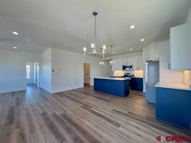 1911 Edison Ave, Alamosa, CO 81101 - kitchen with appliances with stainless steel finishes, open floor plan, an island with sink, a chandelier, and recessed lighting