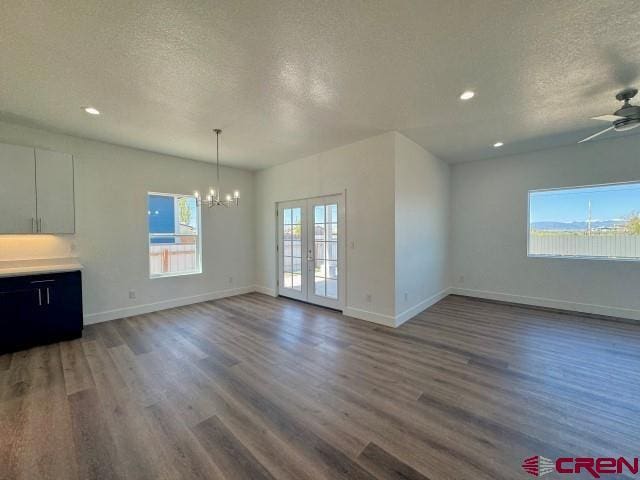 1911 Edison Ave, Alamosa, CO 81101 - unfurnished living room with a textured ceiling, a chandelier, wood finished floors, baseboards, and ceiling fan
