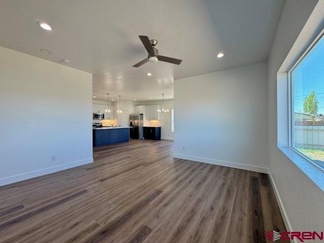 1911 Edison Ave, Alamosa, CO 81101 - unfurnished living room featuring a ceiling fan, dark wood-style flooring, recessed lighting, and baseboards