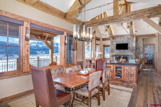 426 Saddle Ridge Ranch Rd, Crested Butte, CO 81224 - dining space featuring a chandelier, hardwood / wood-style flooring, a large fireplace, beverage cooler, and baseboards