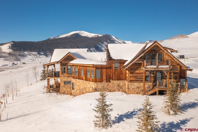 426 Saddle Ridge Ranch Rd, Crested Butte, CO 81224 - view of front of property with stone siding, stairs, a balcony, and a mountain view