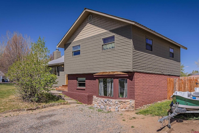 399 E Schroder Dr, Bayfield, CO 81122 - view of home's exterior featuring stone siding and a chimney