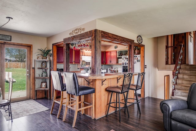 399 E Schroder Dr, Bayfield, CO 81122 - kitchen with dark wood-type flooring, a breakfast bar, light countertops, open shelves, and white fridge with ice dispenser