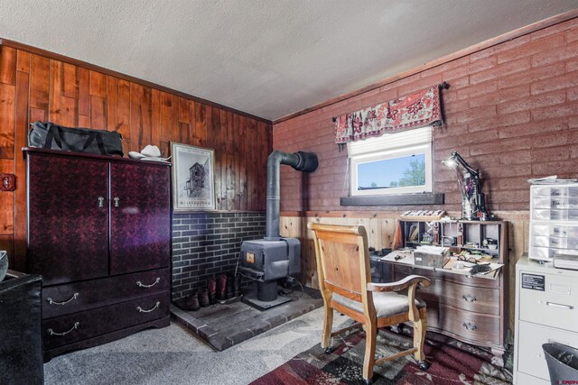 399 E Schroder Dr, Bayfield, CO 81122 - office space with a wood stove, wooden walls, a textured ceiling, and carpet floors