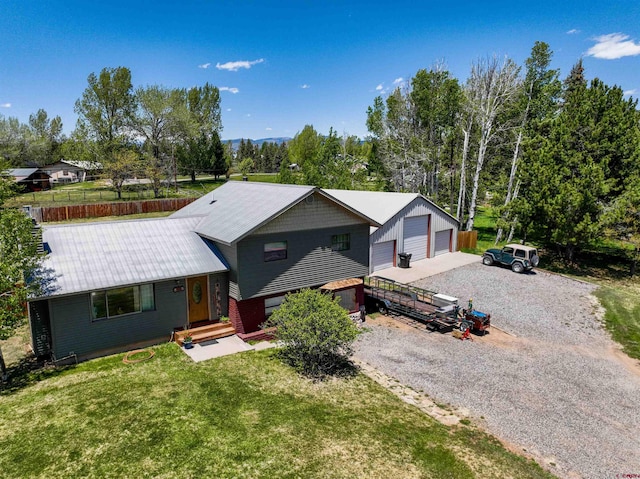 399 E Schroder Dr, Bayfield, CO 81122 - tri-level home with a garage, a front lawn, view of wooded area, metal roof, and an outdoor structure