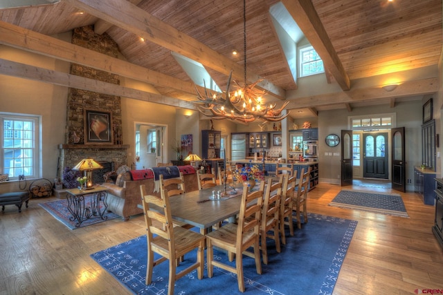 575 County Rd 253, Durango, CO 81301 - dining room featuring high vaulted ceiling, wood ceiling with exposed beams, a stone fireplace, a chandelier, and light wood-type flooring