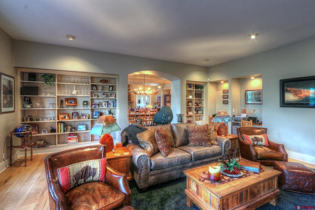 575 County Rd 253, Durango, CO 81301 - living room featuring a chandelier, arched walkways, wood finished floors, and baseboards