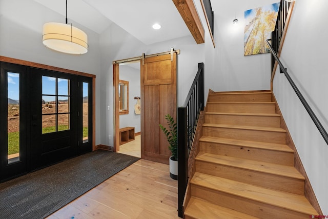 64 Buckhorn Way, Crested Butte, CO 81224 - foyer entrance featuring a barn door, hardwood / wood-style floors, stairway, high vaulted ceiling, and baseboards