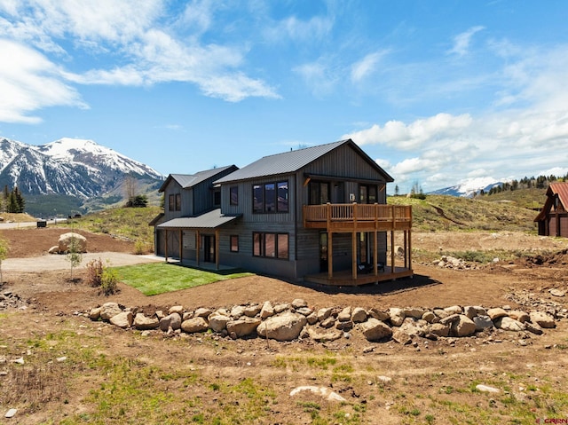 64 Buckhorn Way, Crested Butte, CO 81224 - back of house with a patio, driveway, a deck with mountain view, metal roof, and an attached garage