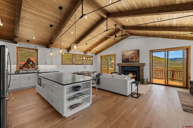 64 Buckhorn Way, Crested Butte, CO 81224 - kitchen with wood ceiling, freestanding refrigerator, dark countertops, open shelves, and white cabinetry