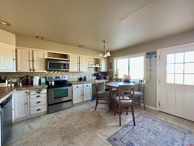 6477 W County Road 9n, Del Norte, CO 81132 - kitchen with stainless steel appliances, a chandelier, open shelves, decorative backsplash, and pendant lighting
