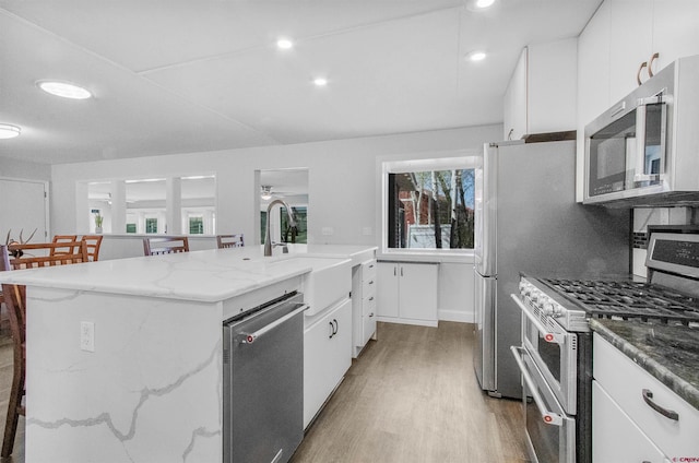 541 Perry Dr, Pagosa Springs, CO 81147 - kitchen featuring appliances with stainless steel finishes, light wood-type flooring, white cabinets, a sink, and recessed lighting